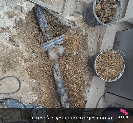 תיקון צנרת עם כלי עבודה ודלי עפר
